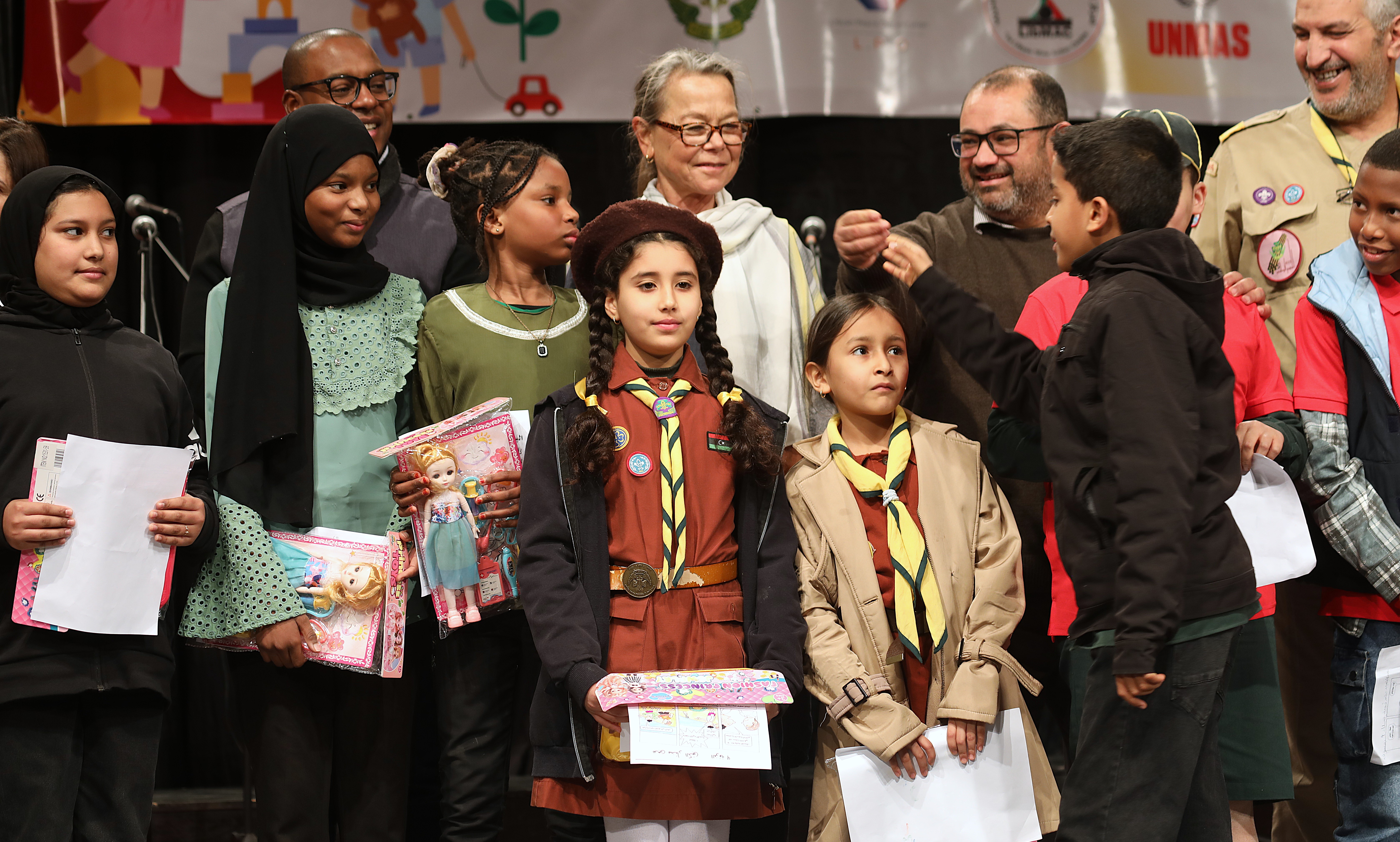 Children and men standing next to DSRSG-RC