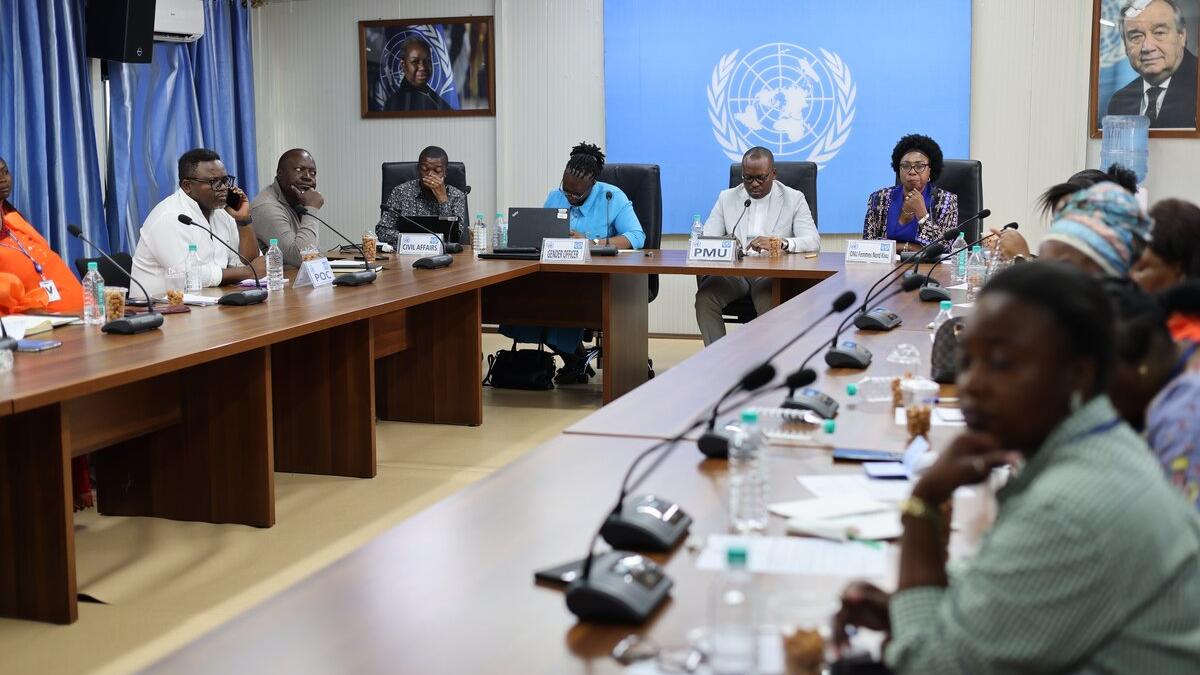 Meeting participants sit around a table.