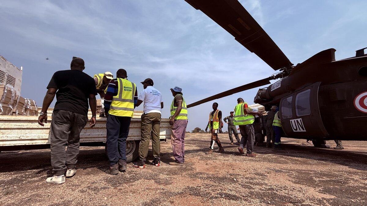 Des représentants de l’ONU transportent des fournitures depuis un hélicoptère de l’ONU.