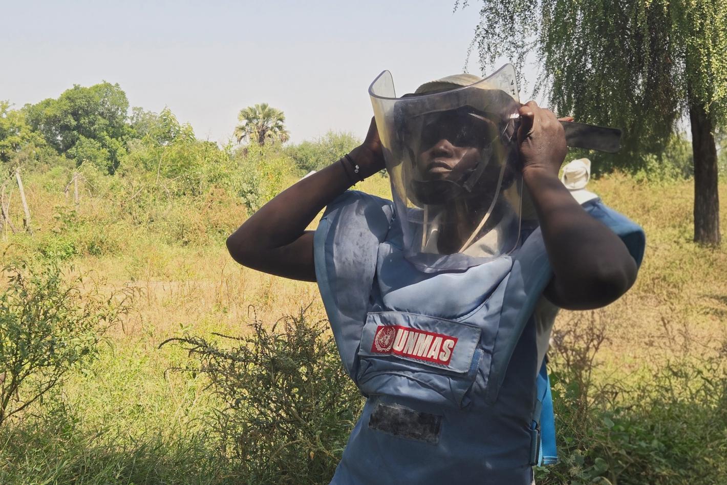a female deminer with a protective mask